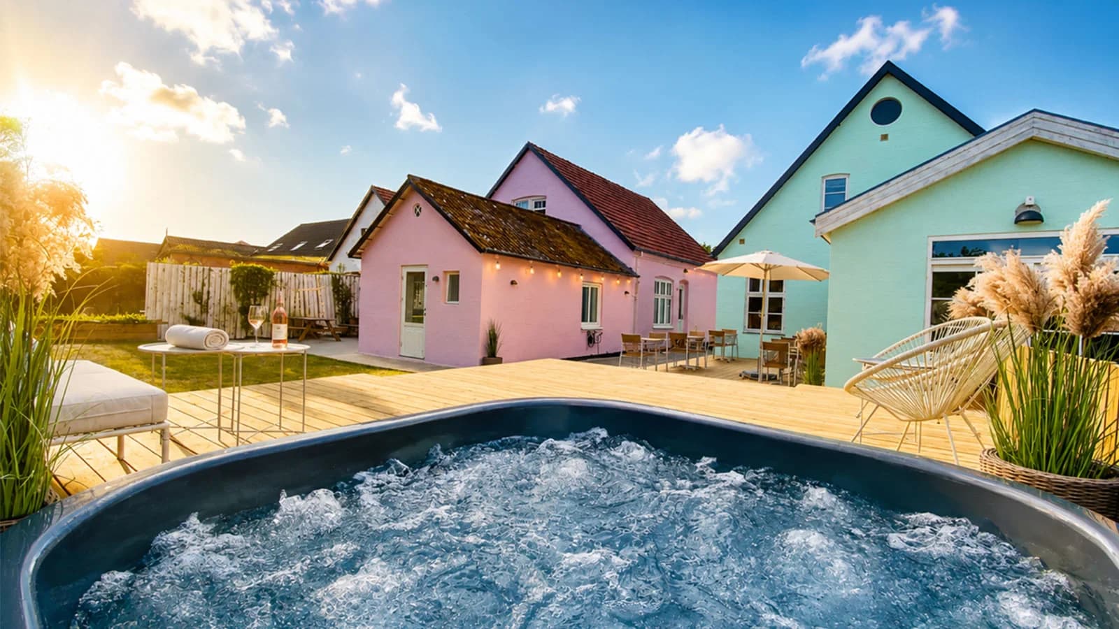 Vildmarksbadet i haven med det lyserøde og det grønne hus bagved