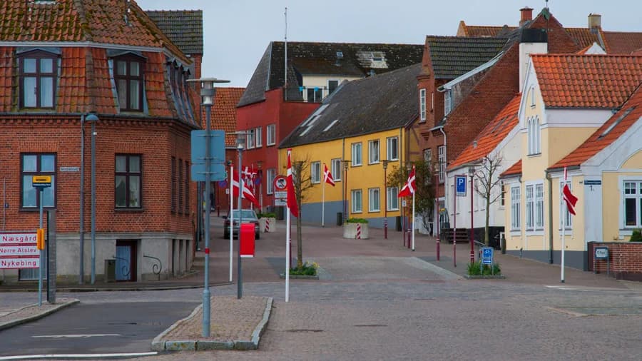 Gade i Stubbekøbings gamle bydel med røde og gule huse og flag
